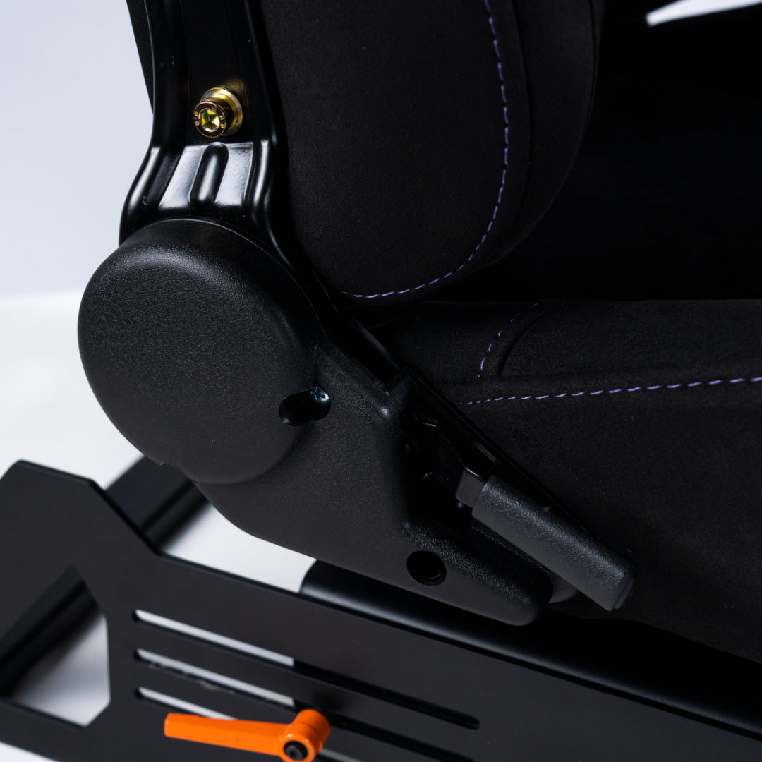 Close-up of a black car seat with a metallic armrest and orange lever on a light gray background