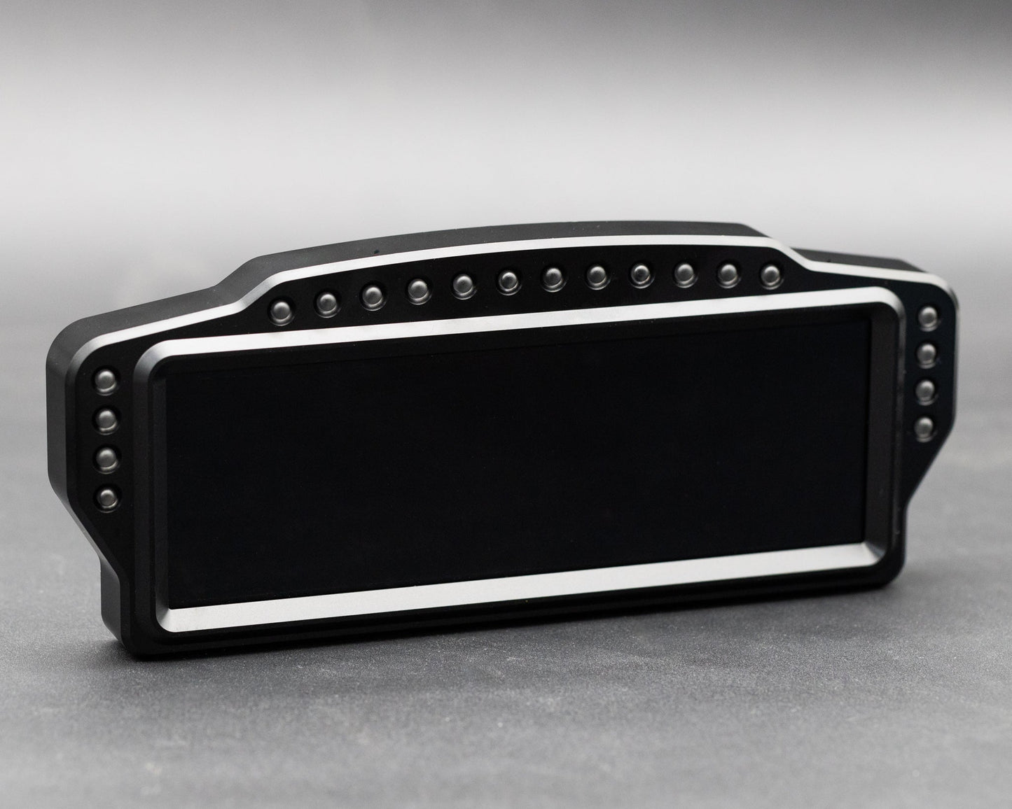 Black rectangular object with metallic accents on a gray background