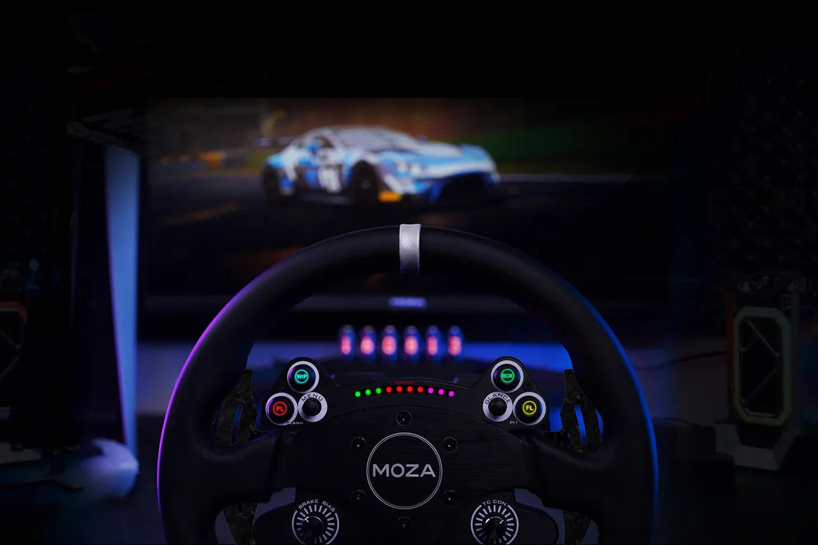 Simulator dashboard with steering wheel and screen displaying a racing game in a dark room.