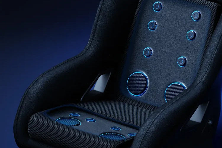 A close-up of a black racing-style bucket seat with blue illuminated circular controls on the backrest and seat, shown against a dark blue studio background.