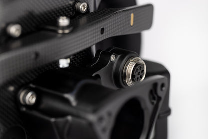 Close-up of a black mechanical component with a metallic connector on a white background