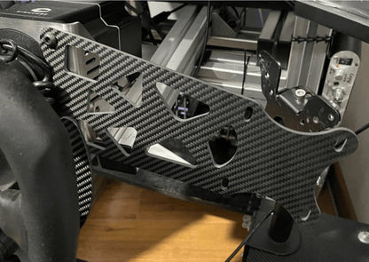 Carbon fiber plate attached to a mechanical or electronic device on a wooden surface.