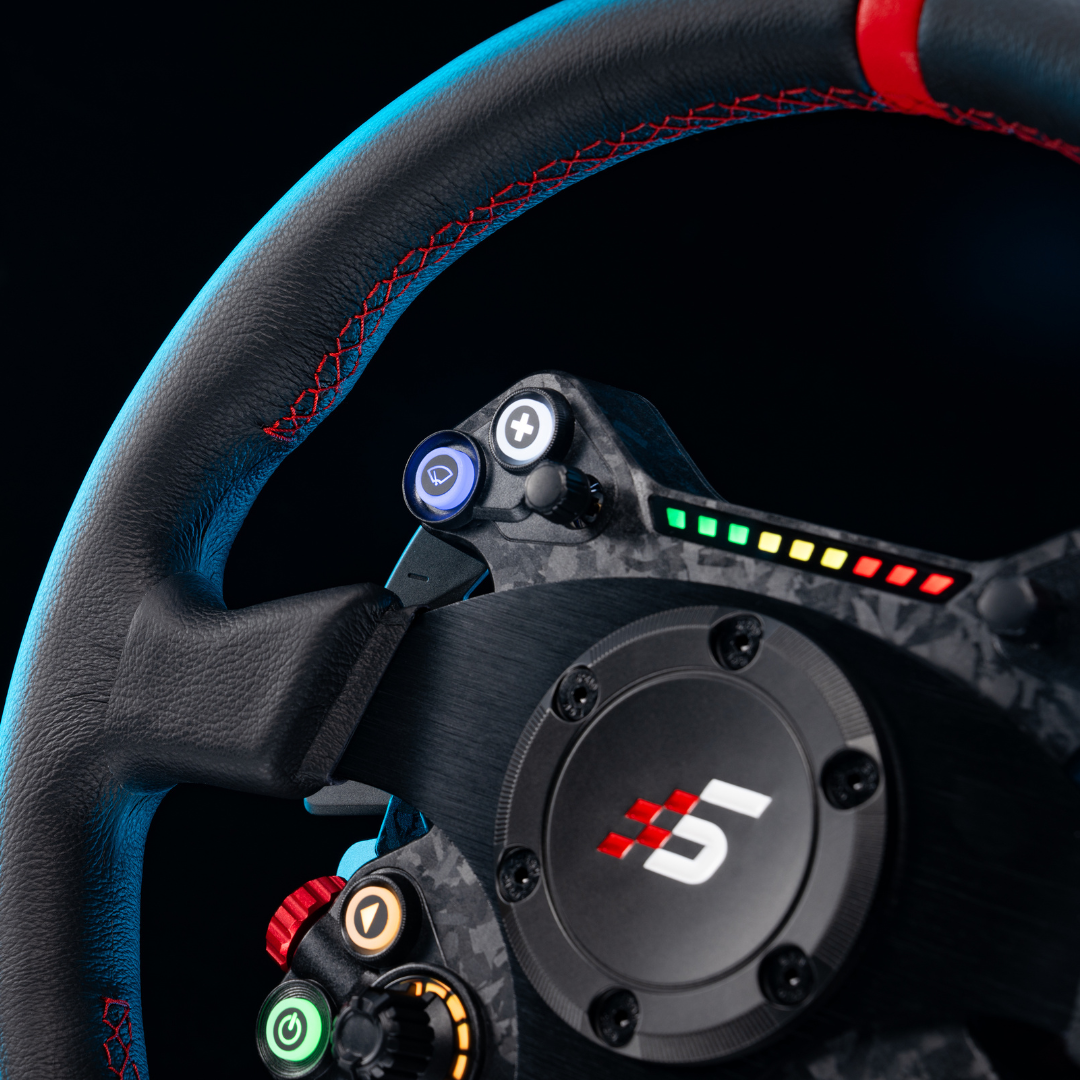 Close-up of a steering wheel with colorful buttons and a brand logo on a black background