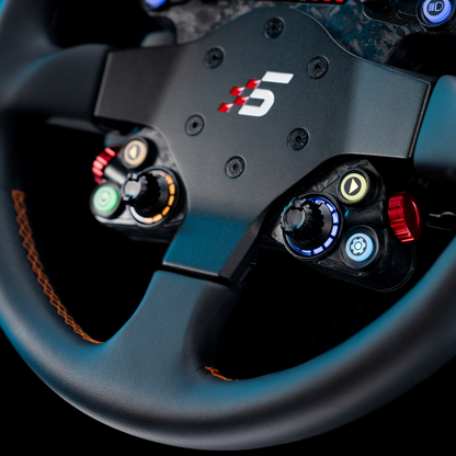 Close-up of a steering wheel with multiple buttons and a logo on a dark background