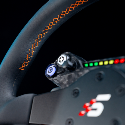 Close-up of a car steering wheel with orange stitching and a digital display.