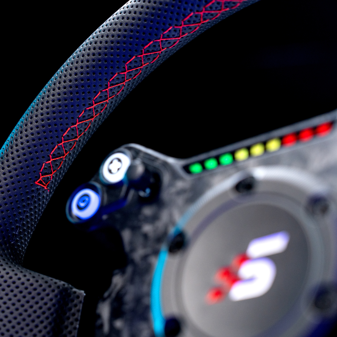 Close-up of a car's steering wheel with illuminated buttons and a blurred 'RS' logo in the background.