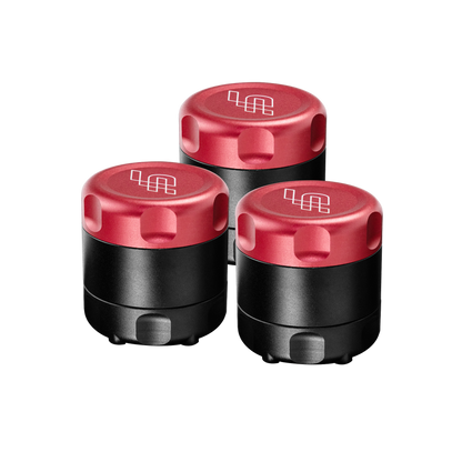 Three black containers with red lids on a white background