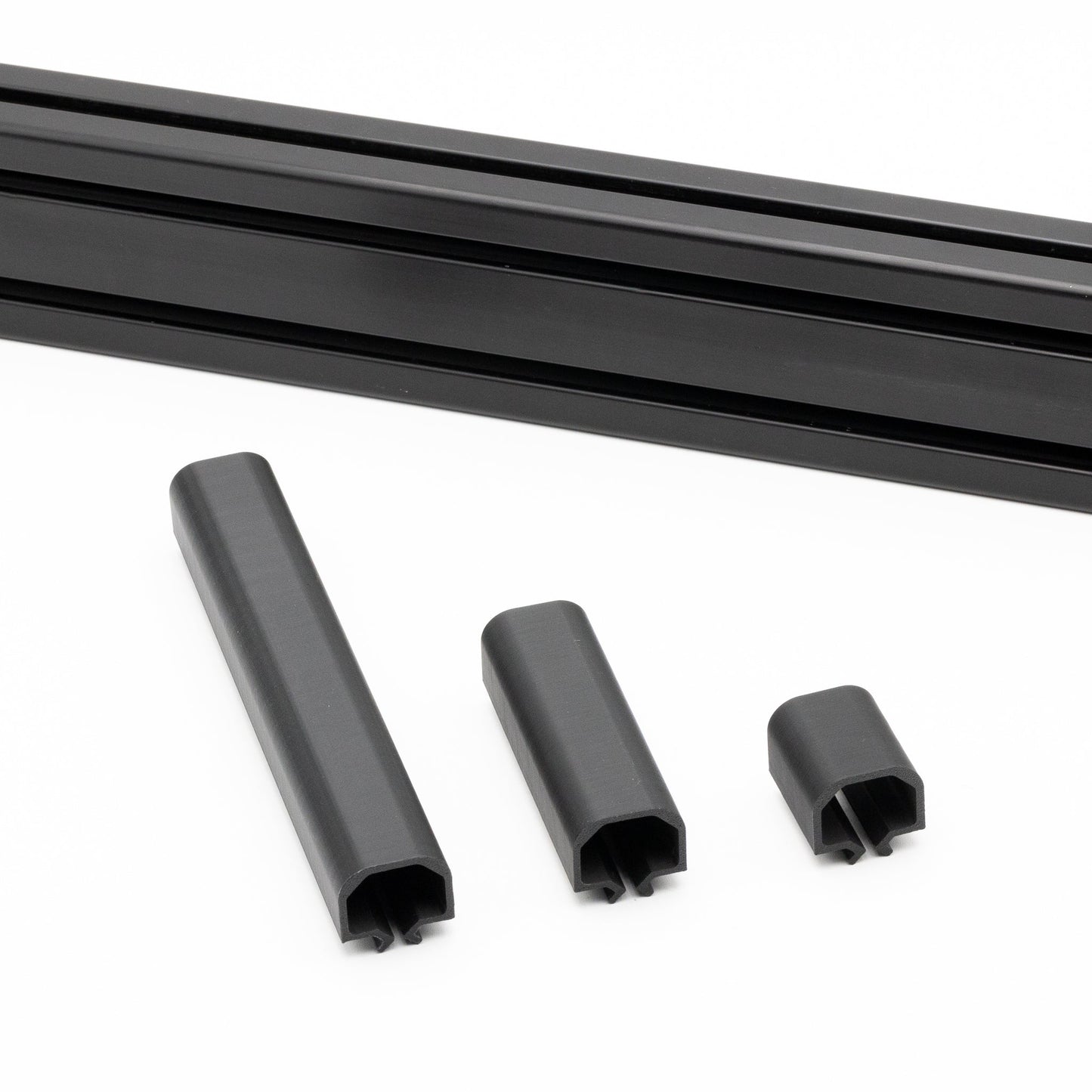 Set of black plastic profiles and connectors on a white background