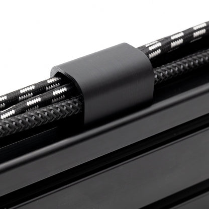Close-up of black cable ties securing black braided cables on a white background