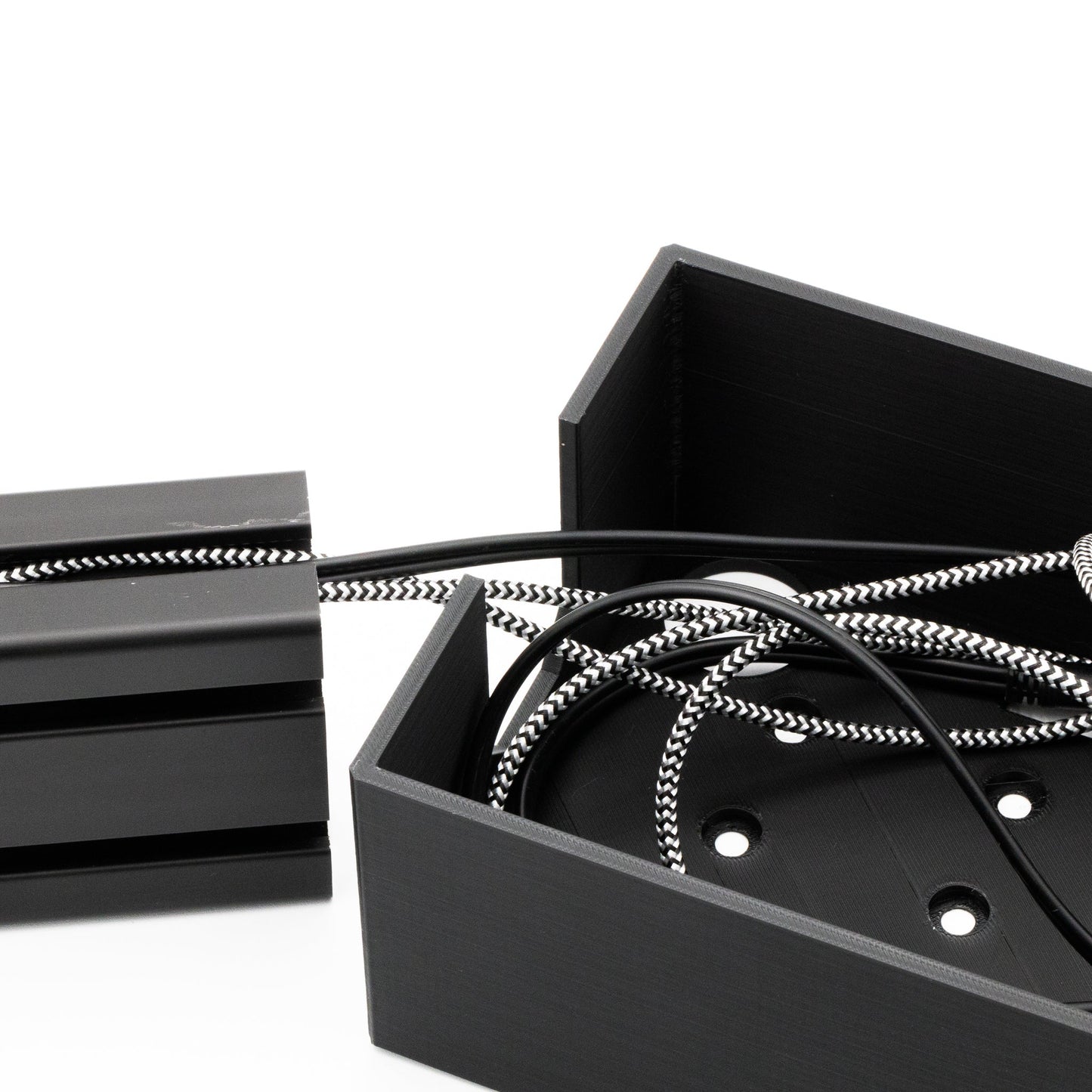 Black metal box with coiled cable on a white background