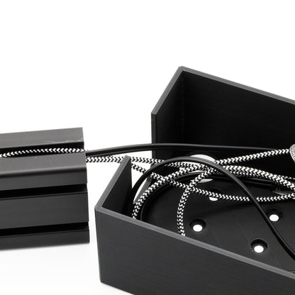Black metal box with coiled cable on a white background
