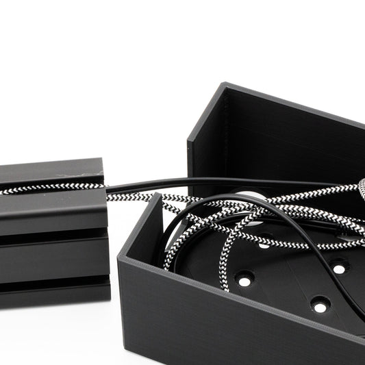 Black metal box with coiled cable on a white background
