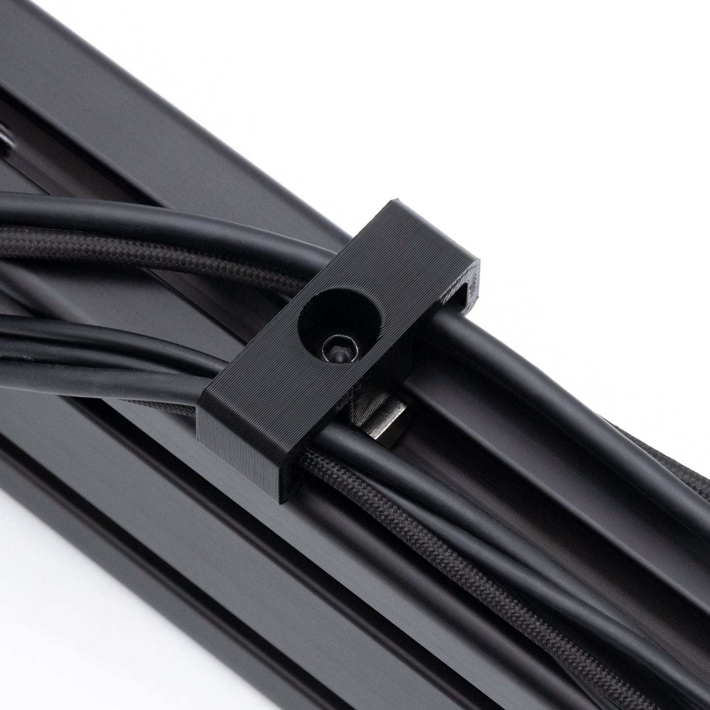 Close-up of a black metal cable management system on a white background