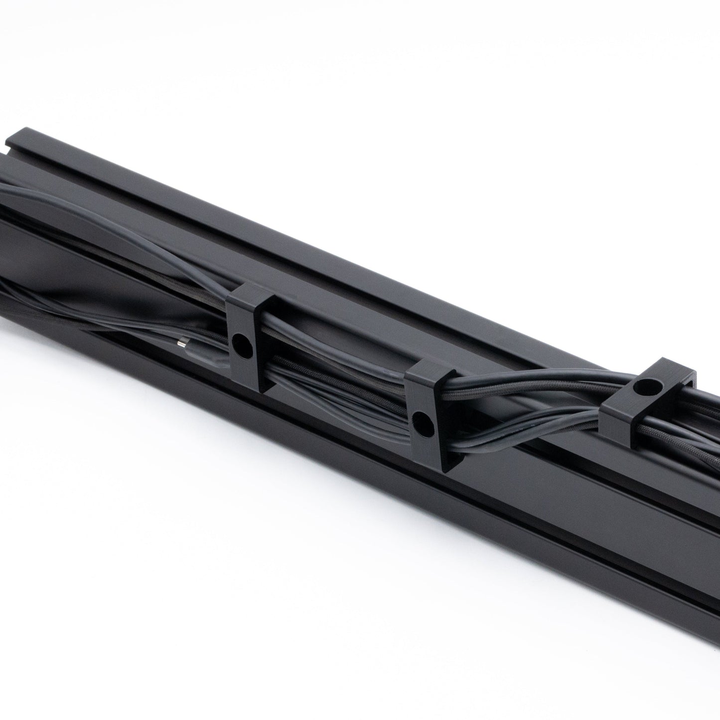 Black metal cable tray with cables on a white background