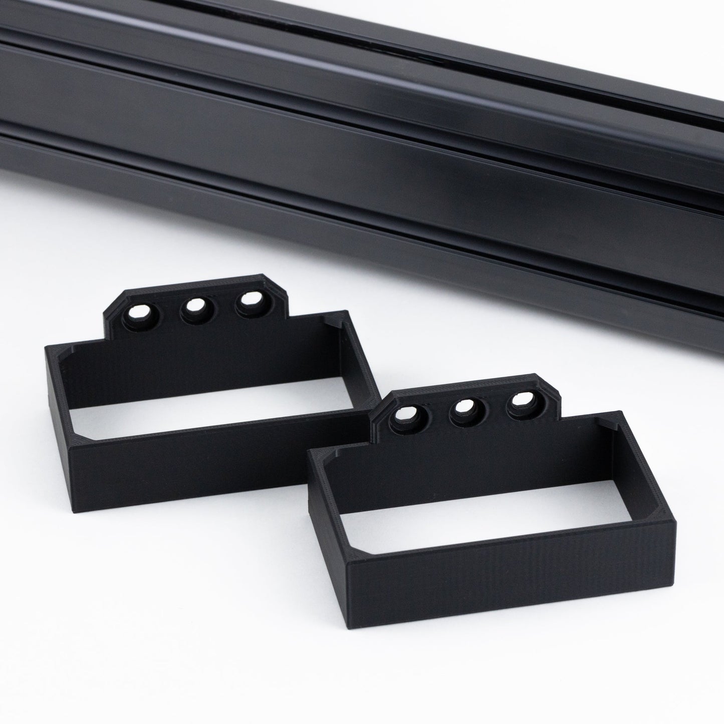 Two black metal brackets on a white background