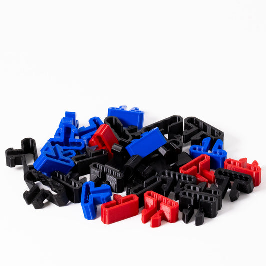 Assorted black, blue, and red plastic building blocks on a white background