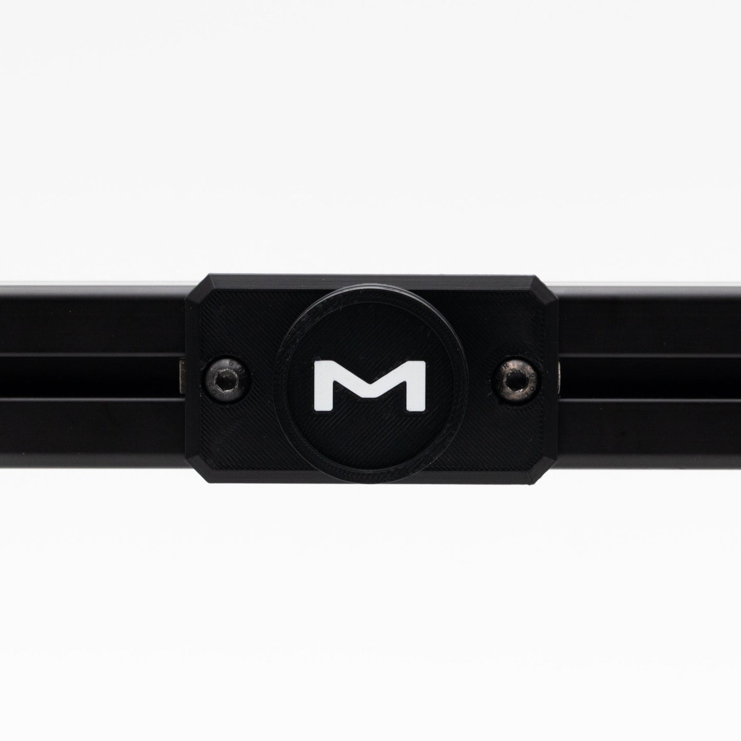 Black metal bar with a circular component featuring a 'M' logo on a white background