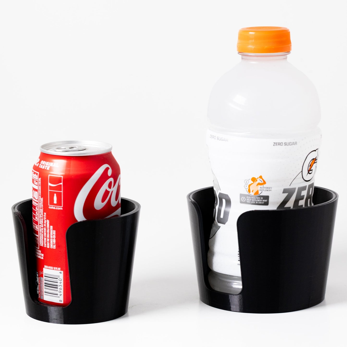 Black drink holder with Coca-Cola can and Diet Coke bottle on a white background