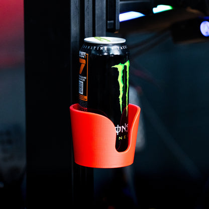 Monster energy drink can in a red cup holder against a dark background