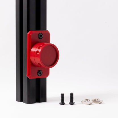 Red lock mechanism attached to a black metal frame with screws on a white background