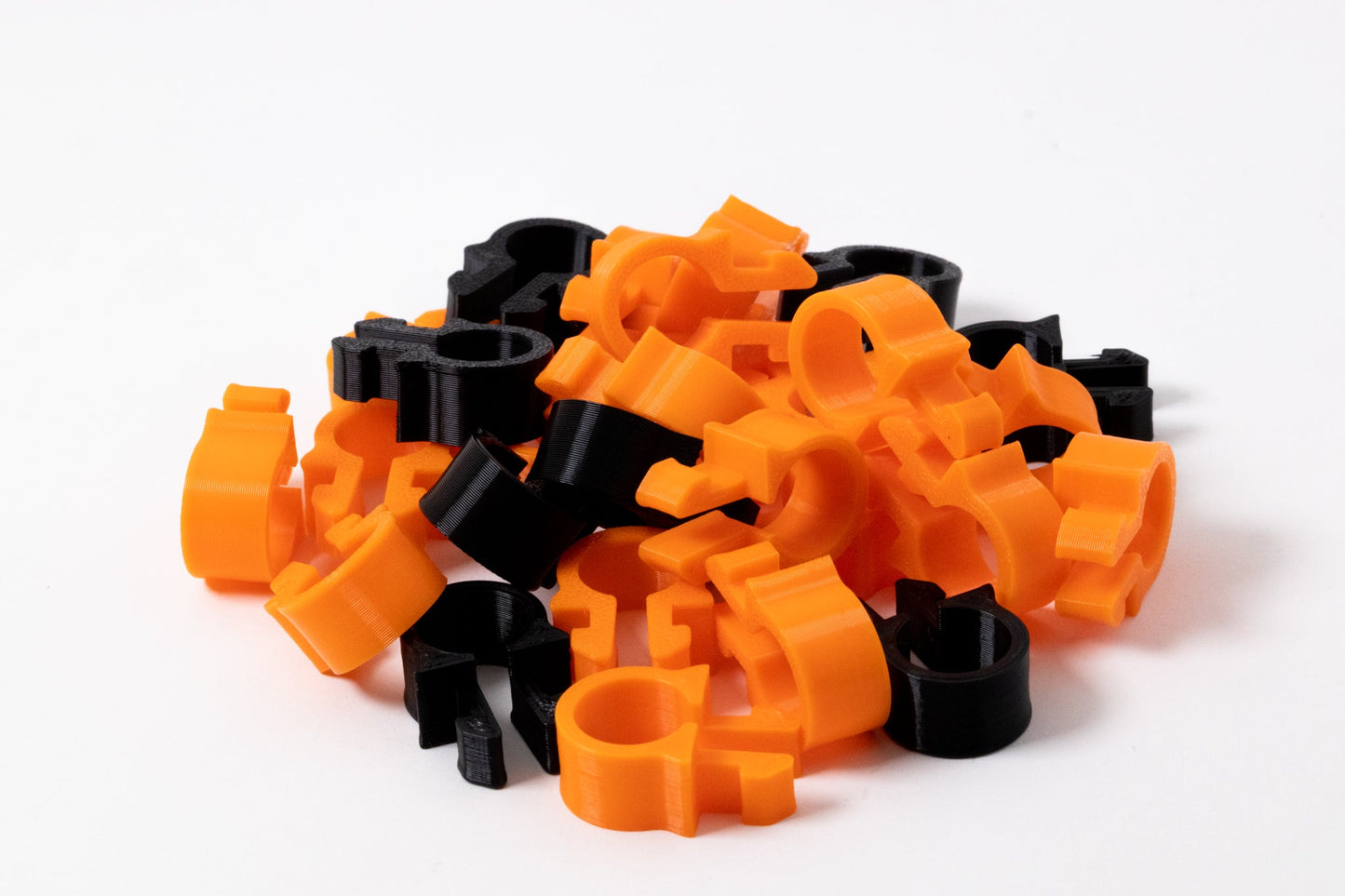 Stack of orange and black plastic interlocking pieces on a white background