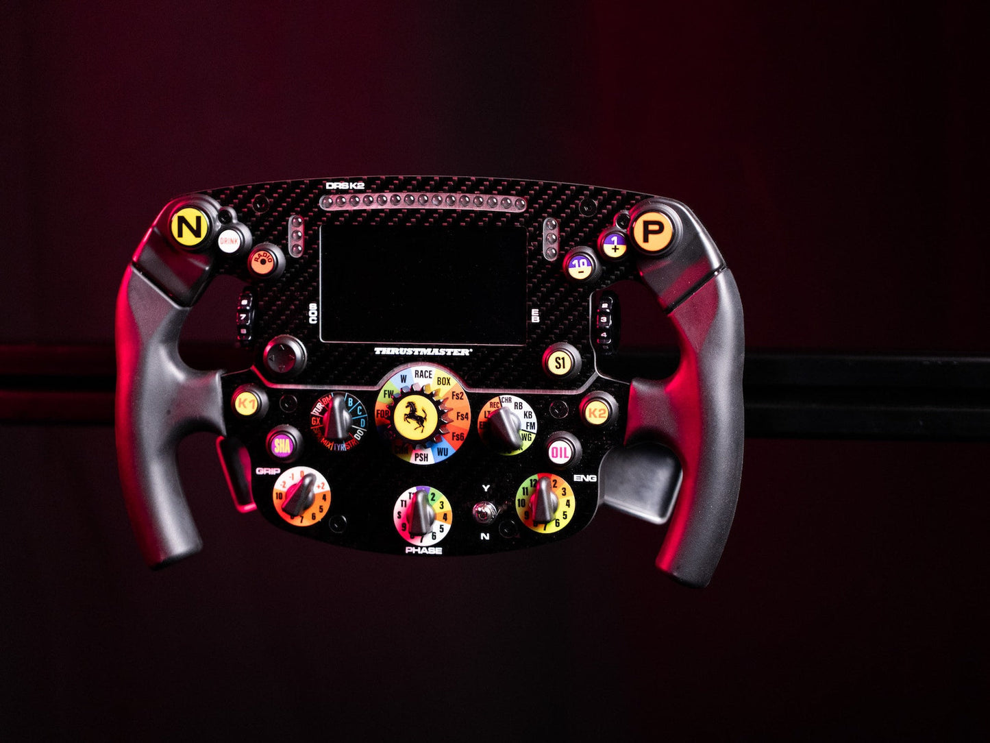 Ferrari steering wheel with carbon fiber finish and colorful buttons on a dark background