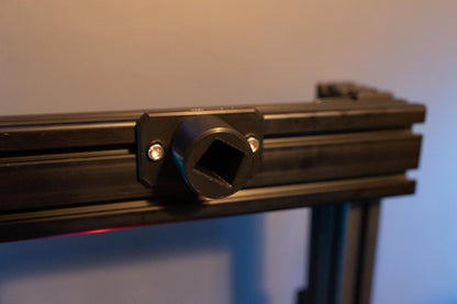 Close-up of a black metal bracket with a hexagonal socket on a blurred background