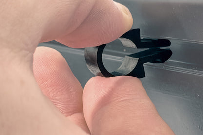 Hand using a tool to remove a car window seal.