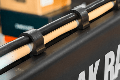 Close-up of a black metal bar with wooden slats on a vehicle, with 'AK Racing' branding.