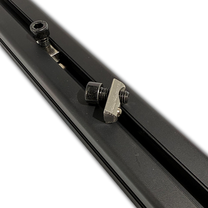 Close-up of a black metal rod with a clamp and screws on a white background
